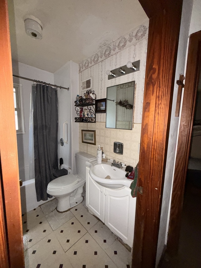 407 North 1st Street Fairbury, IL 61739 - Photo 8 of 22 a bathroom with a sink toilet and shower