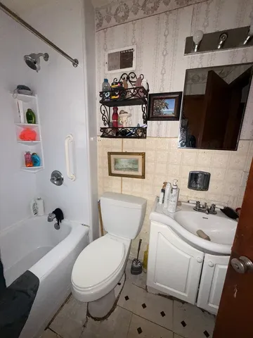 a bathroom with a sink toilet tub and mirror