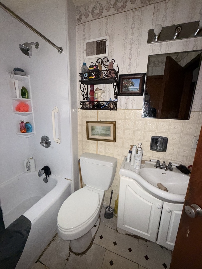 407 North 1st Street Fairbury, IL 61739 - Photo 9 of 22 a bathroom with a sink toilet tub and mirror