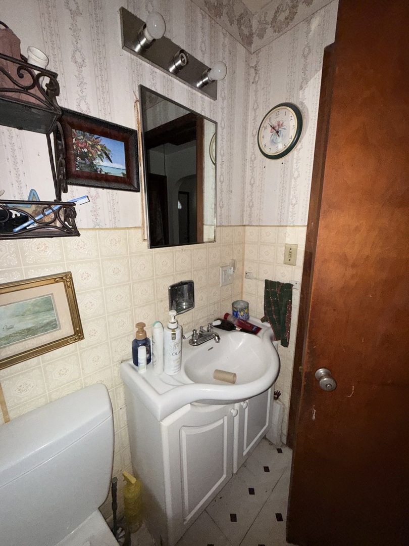 407 North 1st Street Fairbury, IL 61739 - Photo 10 of 22 a bathroom with a sink a mirror and a shower