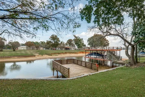 a view of a lake with a bench and trees