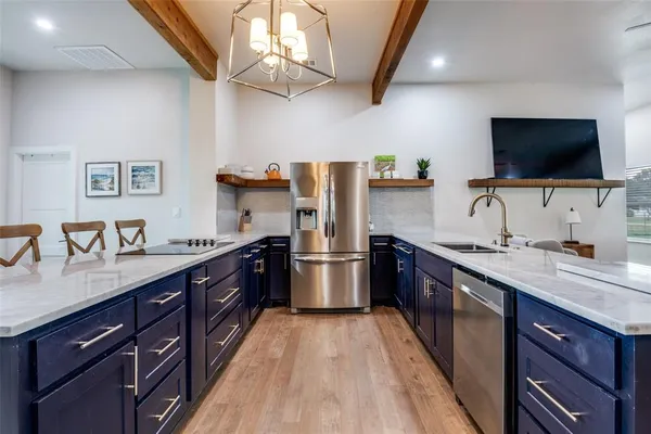 a large kitchen with stainless steel appliances granite countertop a lot of counter space and a sink