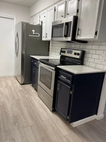 a kitchen with stainless steel appliances granite countertop a stove a refrigerator and a microwave