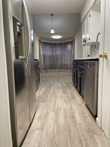 a view of a kitchen with a sink and refrigerator