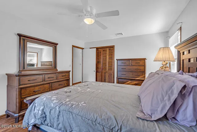 a bedroom with a bed and dresser with mirror