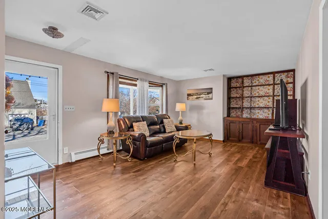 a living room with furniture and a wooden floor