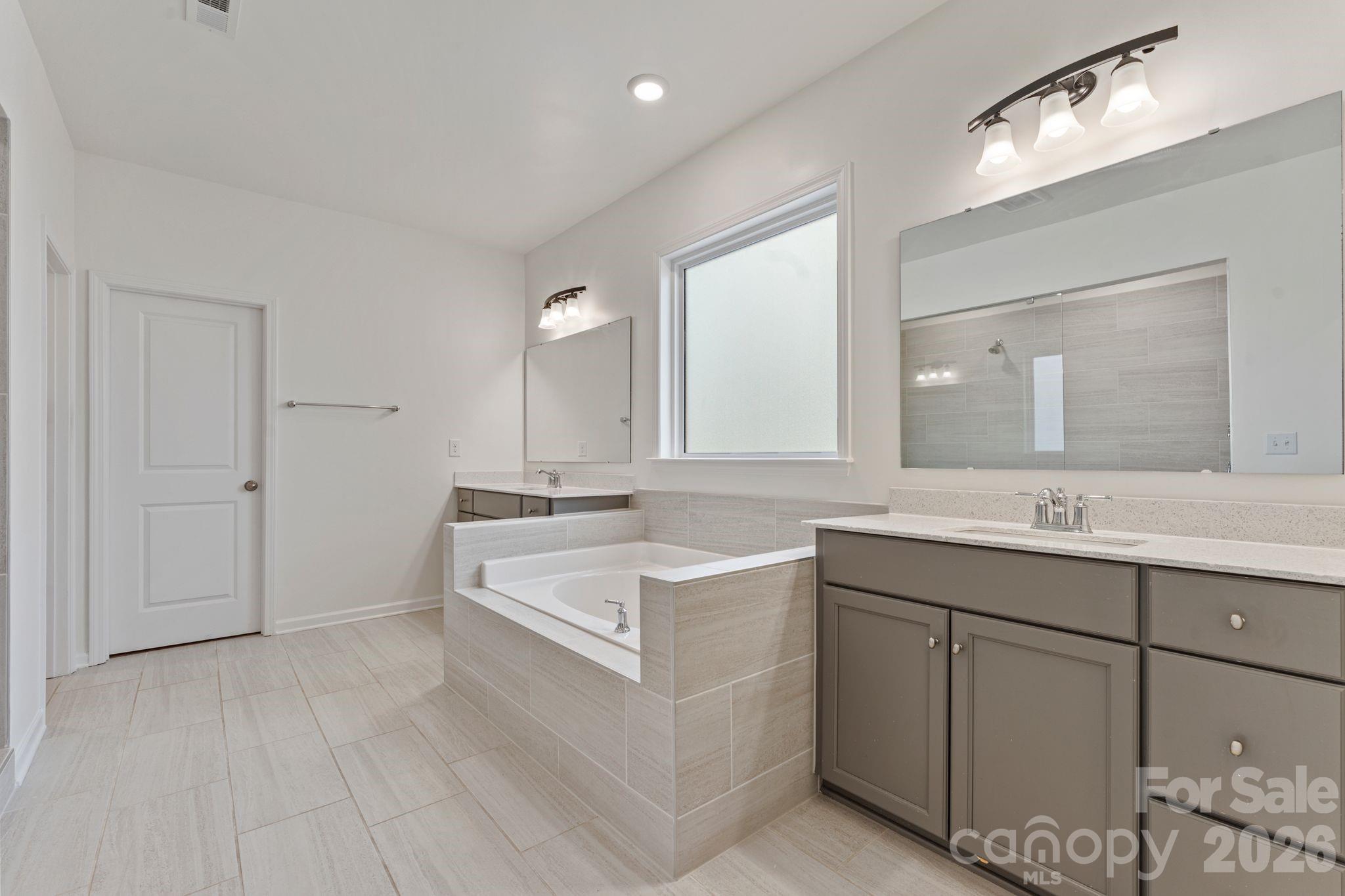9786 Verdun Court Fort Mill, SC 29707 - Photo 18 of 41 a spacious bathroom with a double vanity sink mirror and bathtub