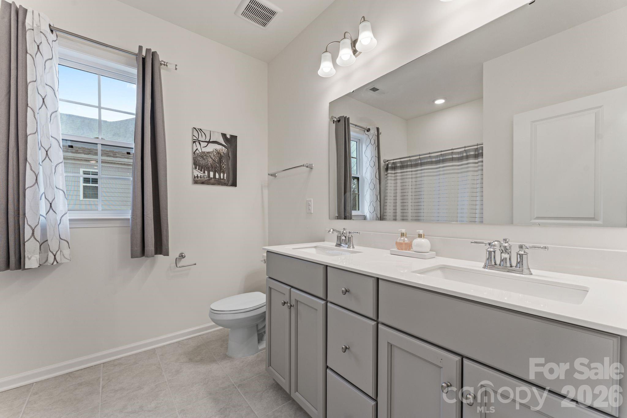 9786 Verdun Court Fort Mill, SC 29707 - Photo 25 of 41 a bathroom with a toilet a sink a mirror a and vanity
