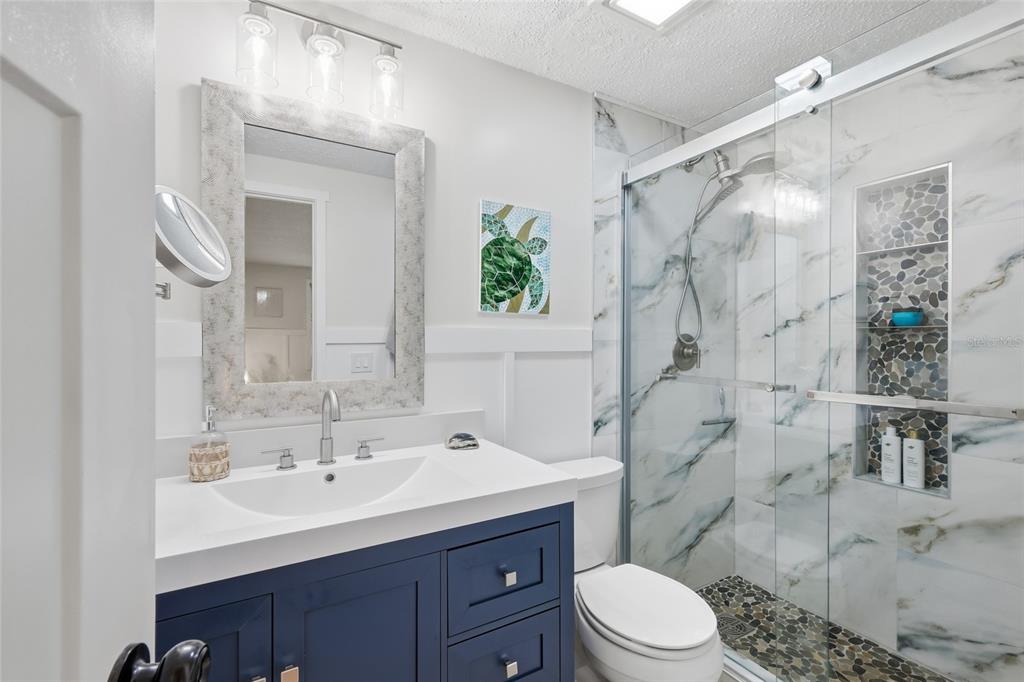 417 63rd Street Holmes Beach, FL 34217 - Photo 17 of 48 a bathroom with a sink toilet a mirror and shower