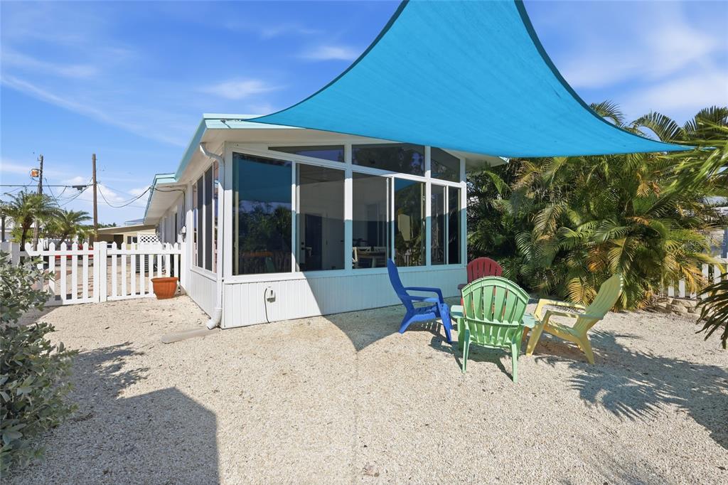 417 63rd Street Holmes Beach, FL 34217 - Photo 23 of 48 a view of a chair and tables in the patio