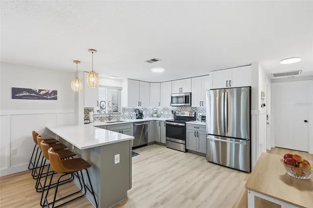 a kitchen with refrigerator cabinets and wooden floor