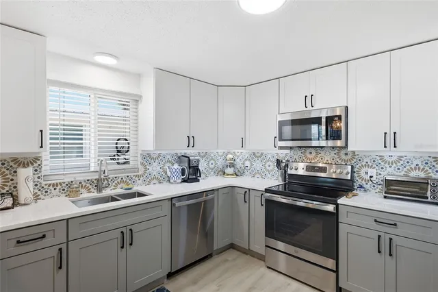 a kitchen with a sink stove and microwave