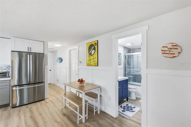 a kitchen with stainless steel appliances wooden floor and a refrigerator