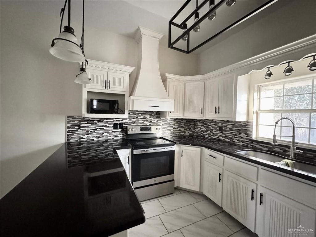 2709 Austin Avenue McAllen, TX 78501 - Photo 6 of 12 a kitchen with stainless steel appliances kitchen island granite countertop a sink a stove and cabinets
