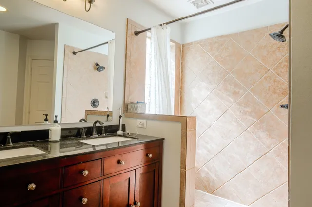 a bathroom with double vanity two mirror and a window