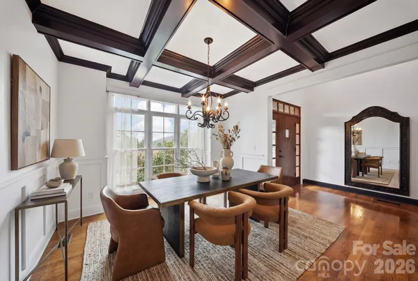 a dining room with furniture a chandelier and wooden floor