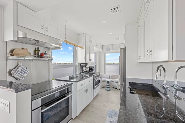 a bathroom with a granite countertop sink a toilet and shower