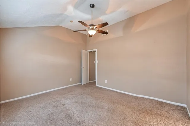 an empty room with a ceiling fan and a window