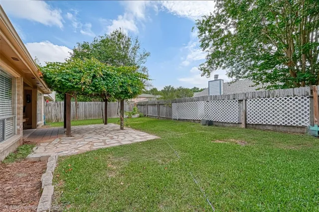 front view of a house with a yard and a large tree
