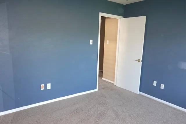an empty room with a ceiling fan and a window