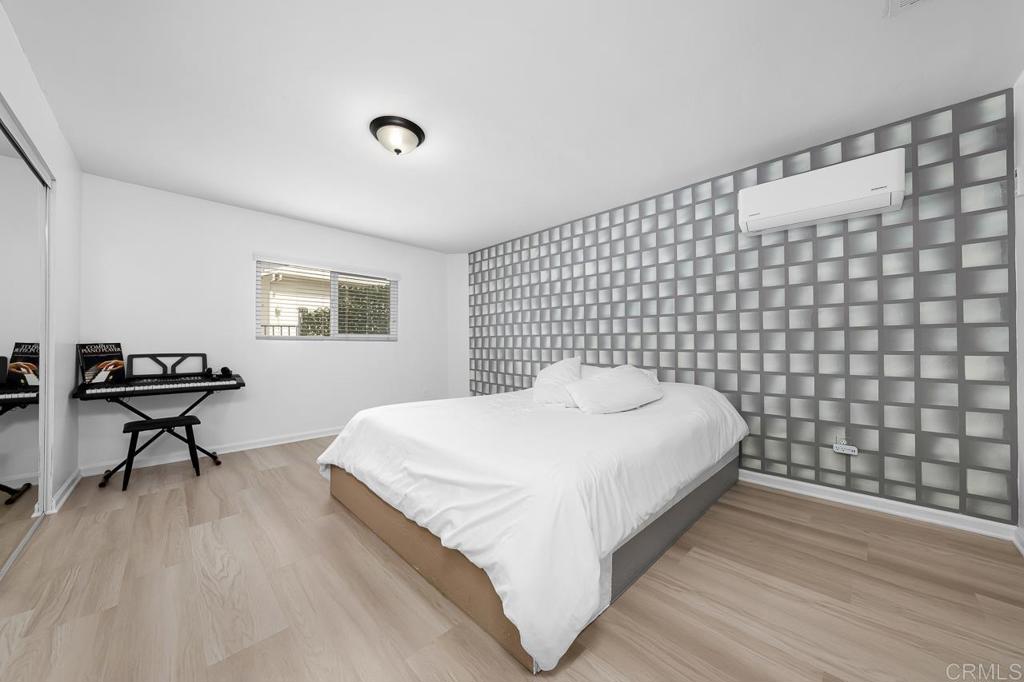 1661 Grove Road El Cajon, CA 92020 - Photo 19 of 44 a large bed sitting in a bedroom next to a window with wooden floor