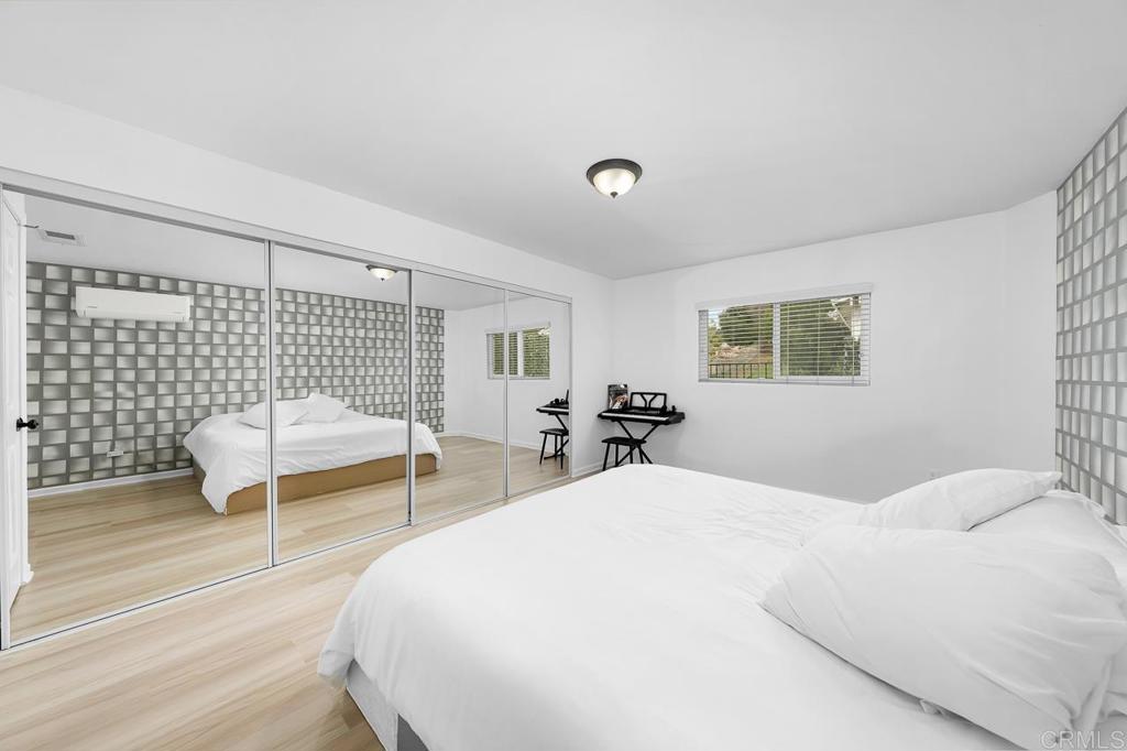 1661 Grove Road El Cajon, CA 92020 - Photo 20 of 44 a bedroom with a bed and a lamp with wooden floor