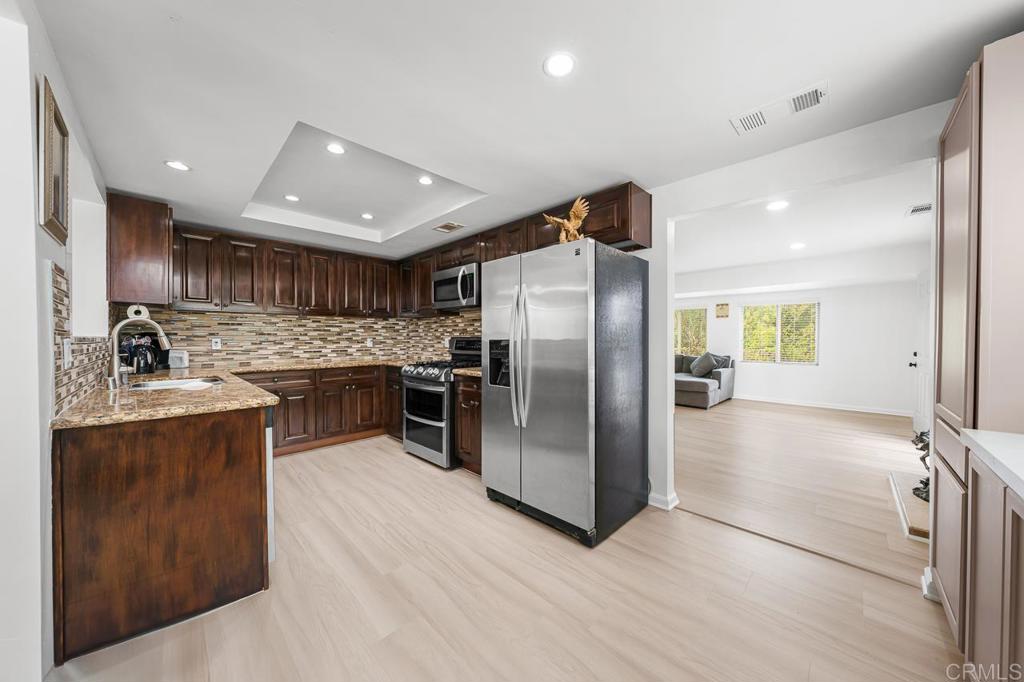 1661 Grove Road El Cajon, CA 92020 - Photo 7 of 44 a kitchen with stainless steel appliances granite countertop a refrigerator a sink a stove and a microwave oven