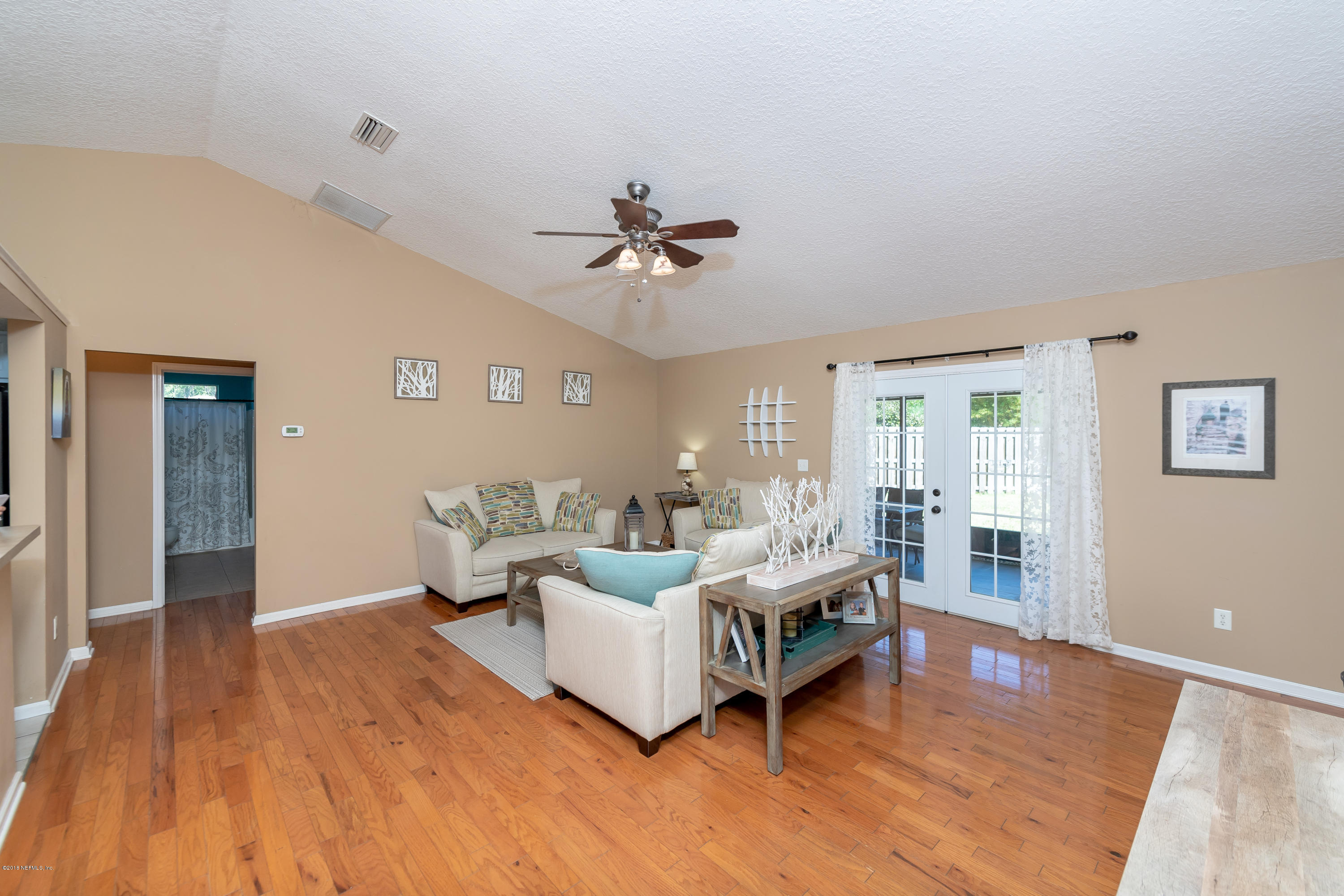 1565 Timber Trace Drive St. Augustine, FL 32092 - Photo 3 of 21 a living room with couches chandelier and a dining table with wooden floor