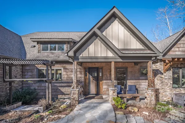 a view of house with patio outdoor seating and covered with tall trees