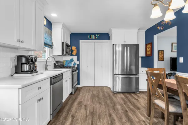 a kitchen with a refrigerator a microwave and wooden floor