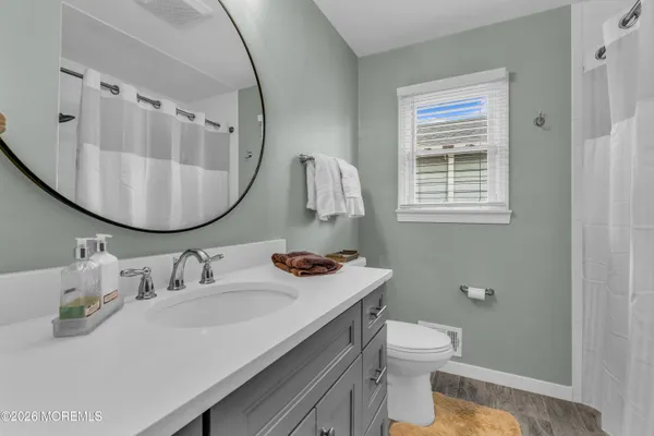 a bathroom with a sink toilet and mirror