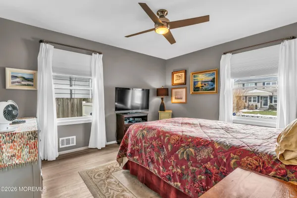 a bedroom with a bed a window and a flat screen television
