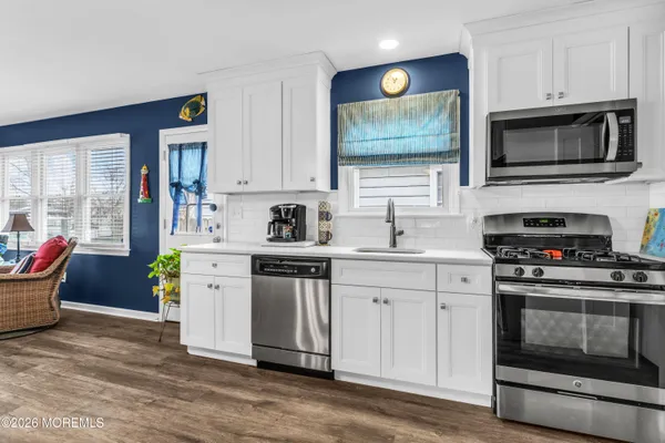 a kitchen with stainless steel appliances a stove microwave and sink