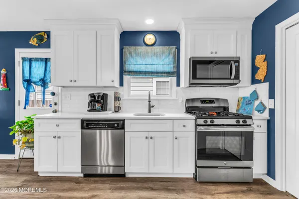 a kitchen with stainless steel appliances granite countertop a stove and cabinets