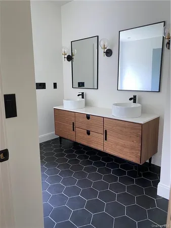 a bathroom with a double vanity sink mirror and bathtub