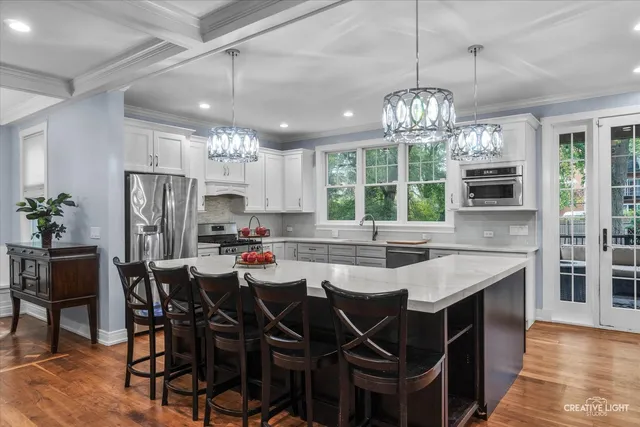 a kitchen with stainless steel appliances a table chairs and chandelier
