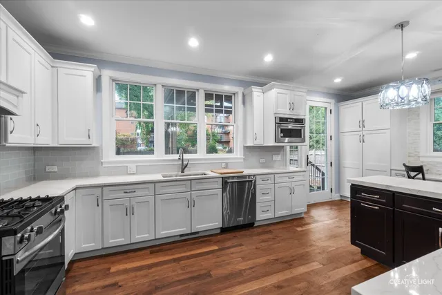 a large kitchen with cabinets wooden floor and stainless steel appliances