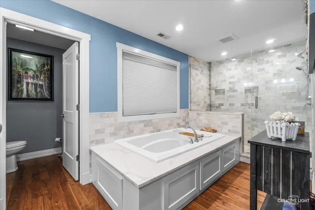 a bathroom with a sink a toilet and a large mirror