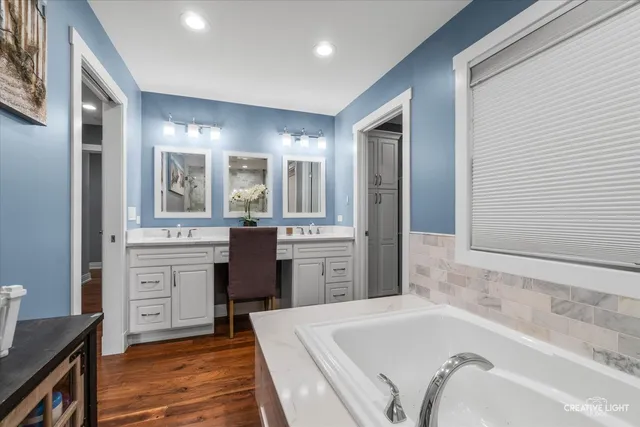 a bathroom with a tub sink and mirror