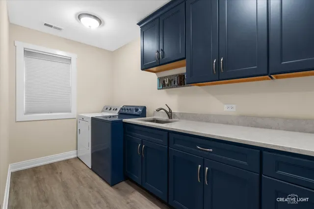 a kitchen with a sink cabinets and wooden floor