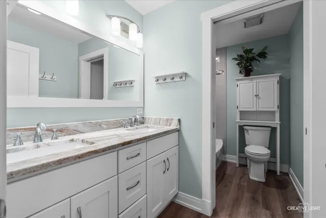 a bathroom with a granite countertop sink a toilet and a mirror