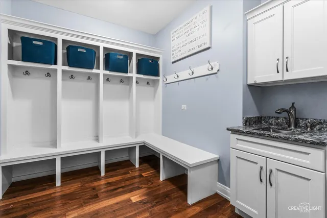 a view of an empty room with cabinet and wooden floor