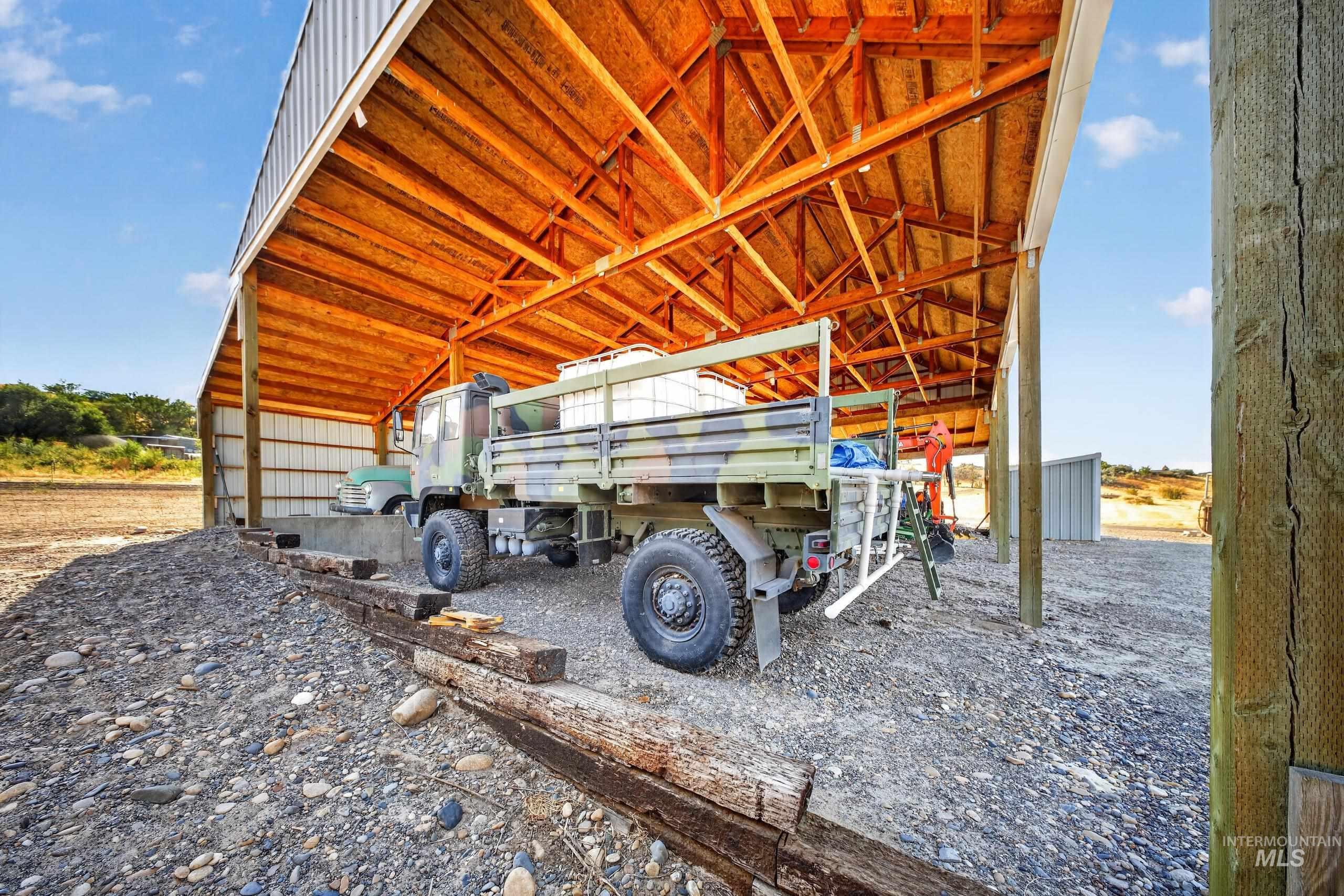 5540 Finley Road Fruitland, ID 83619 - Photo 47 of 50 Open-sided barn structure with a wood-framed roof, metal siding, and a gravel floor