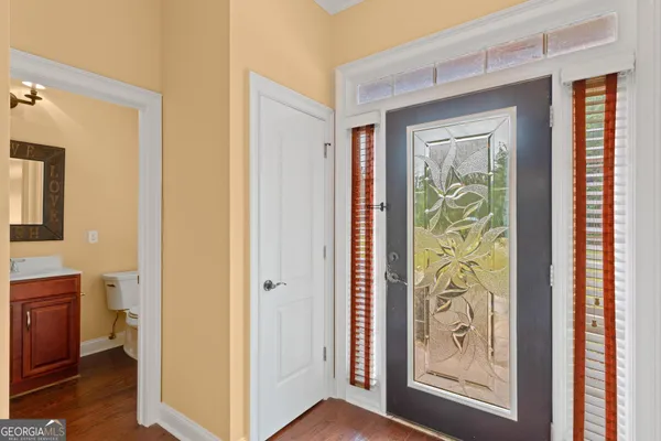 a view of a hallway with bathroom and front door