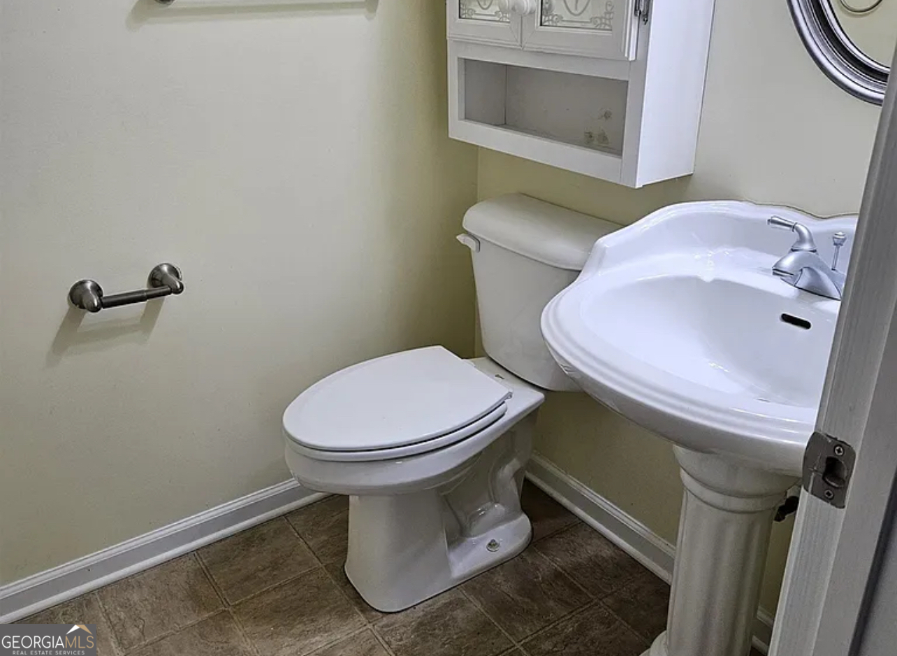 968 Mill Road McDonough, GA 30253 - Photo 68 of 77 a white toilet sitting next to a bathroom sink