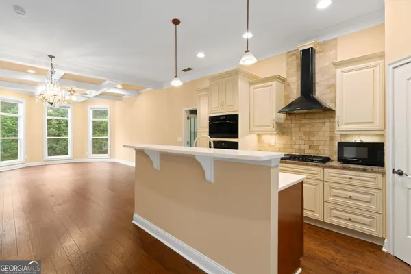 a kitchen with stainless steel appliances granite countertop a stove and a wooden floors