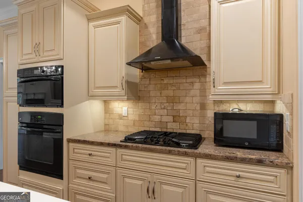 a kitchen with stainless steel appliances granite countertop a refrigerator a oven a sink and a dining table with wooden floor