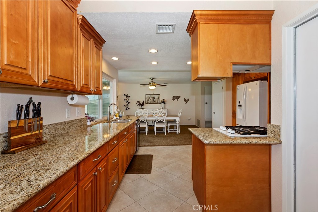 8527 Hillside Road Rancho Cucamonga, CA 91701 - Photo 19 of 50 a kitchen with stainless steel appliances granite countertop a sink a stove and a wooden cabinets