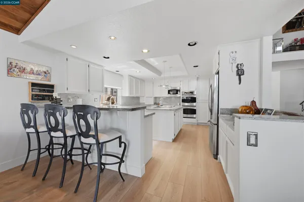 a kitchen with granite countertop a sink stove and cabinets