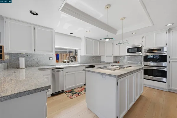 a kitchen with stainless steel appliances granite countertop a sink and cabinets